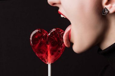 siyah izole kalp şeklinde lolipop yalama kadın kırpılmış görüntü, sevgililer günü kavramı