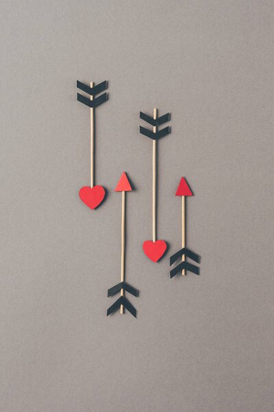 top view of four arrows on gray surface, valentines day concept