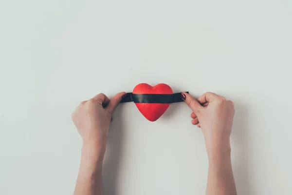 裁剪图像的女人把绝缘磁带在红色的心脏在白色 情人节的概念 — 图库照片