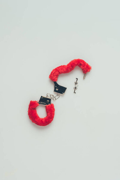 top view of red fluffy handcuffs with keys isolated on white, valentines day concept