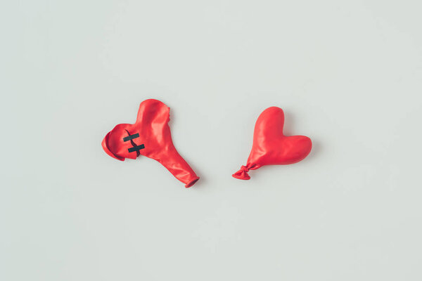 top view of two deflated heart shaped balloons isolated on white, valentines day concept