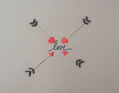 Top view of four arrows and word love on gray surface clipart