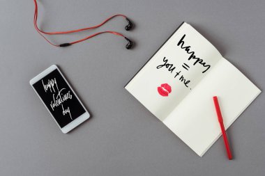 Kelimeler mutlu sevgililer günü ve dudakları gri yüzeye baskı ile dizüstü bilgisayar ile akıllı telefon üst görünümü