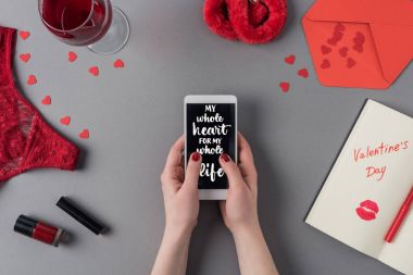 Tüm hayatım boyunca tüm kalbimle akıllı telefon tutan kadının kırpılmış görüntüsü