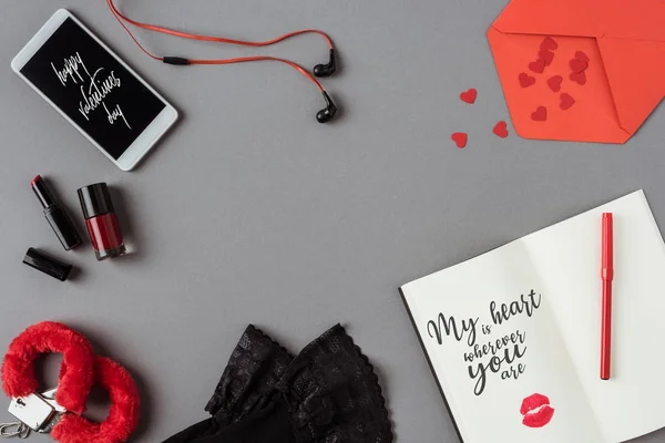 灰色の表面にテキスト幸せなバレンタインデーとノートブックとスマートフォンのトップビュー — ストック写真
