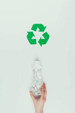 kadın holding plastik şişe geri dönüşüm işareti gri izole ile kısmi görünümünü