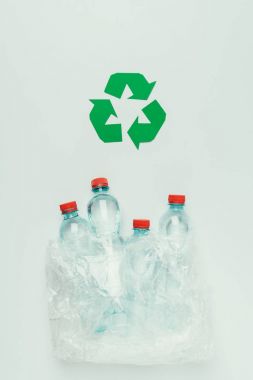 top view of recycle sign and plastic bottles in plastic bag isolated on grey clipart
