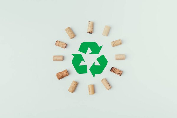 top view of recycle sign and bottle corks around isolated o grey
