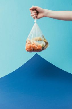kırpılan atış plastik torba çöp mavi arka plan üzerinde tutan kadın