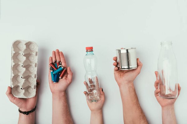 partial view of group of people holding various types of garbage isolated on grey