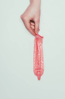 gri izole elinde tutan kadın açılan kısmi görünümünü prezervatif