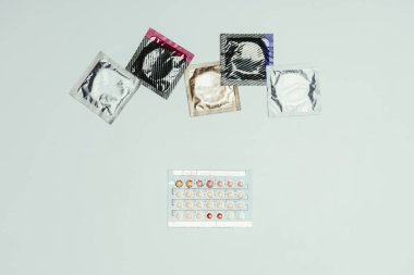 Düzenlenmiş prezervatif ve doğum kontrol hapları gri izole Üstten Görünüm