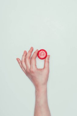 gri izole elinde tutan kadın açılan kısmi görünümünü prezervatif