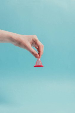 Mavi izole elinde tutan kadın açılan kısmi görünümünü prezervatif