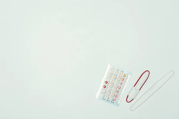 在灰色的避孕丸和妊娠试验的顶部视图 — 免费的图库照片