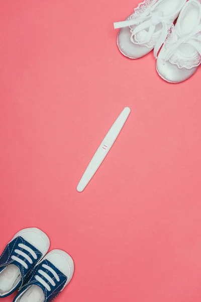Widok Góry Układu Dziecinne Buty Test Ciążowy Różowym Tle — Zdjęcie stockowe