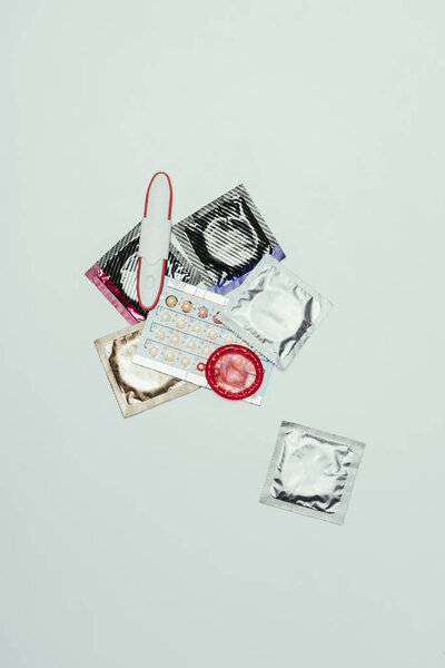 top view of pregnancy test and contraceptives isolated on grey