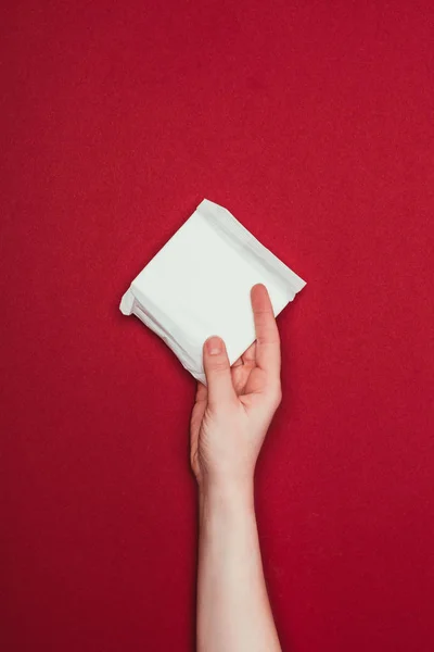 Частичный Взгляд Женщины Держащей Руке Менструальный Блокнот Изолированный Красном — стоковое фото