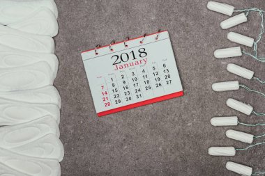 top view of arranged menstrual pads, tampons and calendar on grey surface clipart