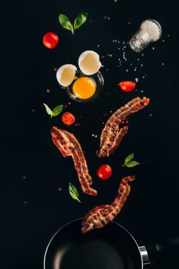 pastırma, domates ve çiğ yumurta sarısı kızartma tavası üzerine siyah izole düşüyor parçalarının görünümü kadar kapatın