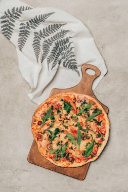 Peçeteye açık renkli ahşap kesme tahtası üzerinde lezzetli pizza