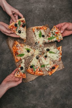 Koyu arka plan üzerinde pizza yemek insanların görünümünü yakın çekim