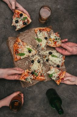 Dilim pizza koyu arka plan üzerine alarak partide insanlar görünümünü yakın çekim