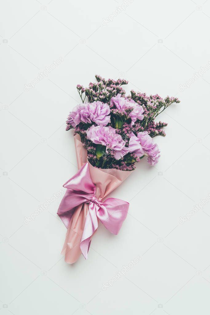 top view of beautiful tender elegant flower bouquet with pink ribbon isolated on grey