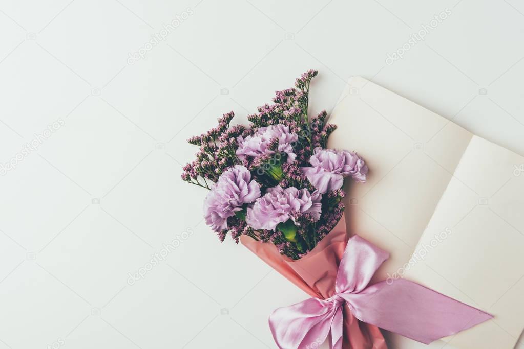 beautiful elegant bouquet of tender purple flowers and blank greeting card isolated on grey