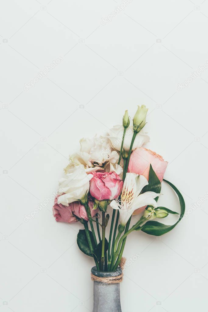 close-up view of beautiful tender flower bouquet in bottle isolated on grey