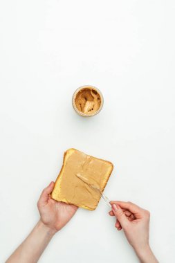 cropped image of woman putting peanut butter on bread isolated on white clipart