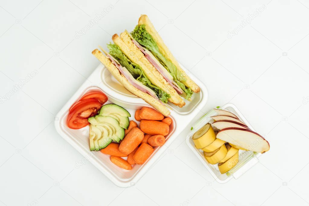 top view of sandwiches, fruits and vegetables in packages isolated on white