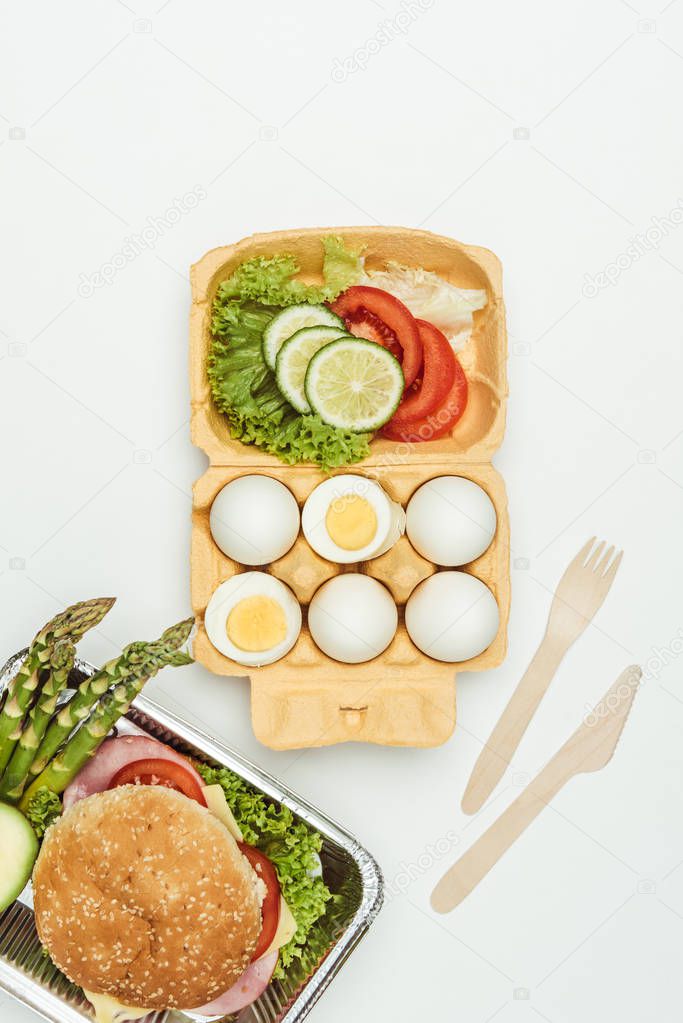 top view of eggs with vegetables and burger isolated on white