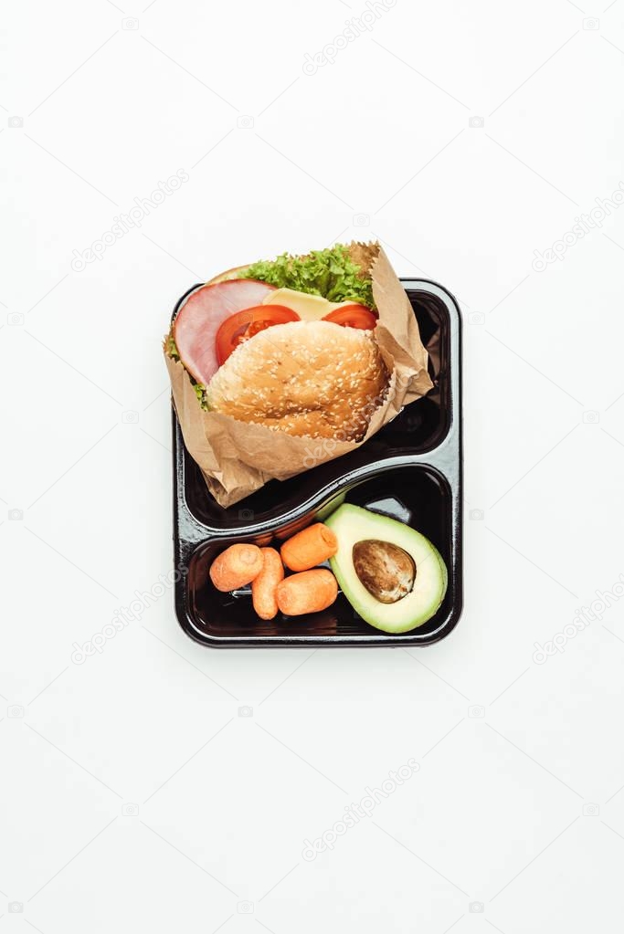 top view of lunch box with burger and vegetables isolated on white