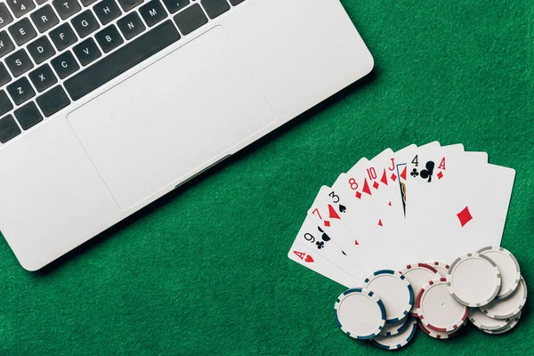 用笔记本电脑在赌场桌上玩纸牌和筹码 — 图库照片
