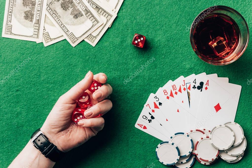 Woman holding dice by casino table with money and chips