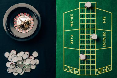 Casino table with roulette and round chips clipart