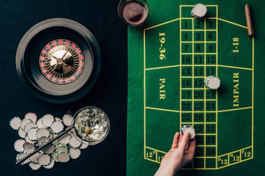 Woman placing a bet on table with roulette clipart