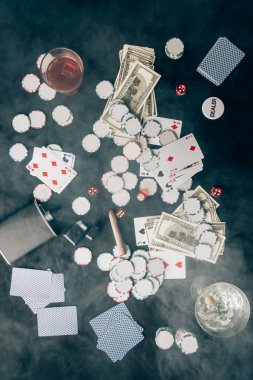 Smoke over chips and money on casino table clipart