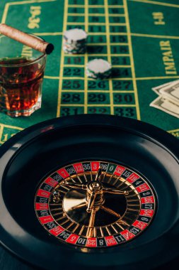 Casino table with roulette and glass with whiskey and cigar clipart