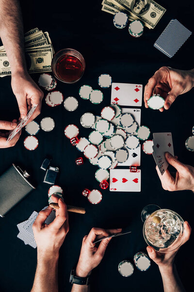 Мужчины и женщины играют в покер за столом казино с картами и фишками
