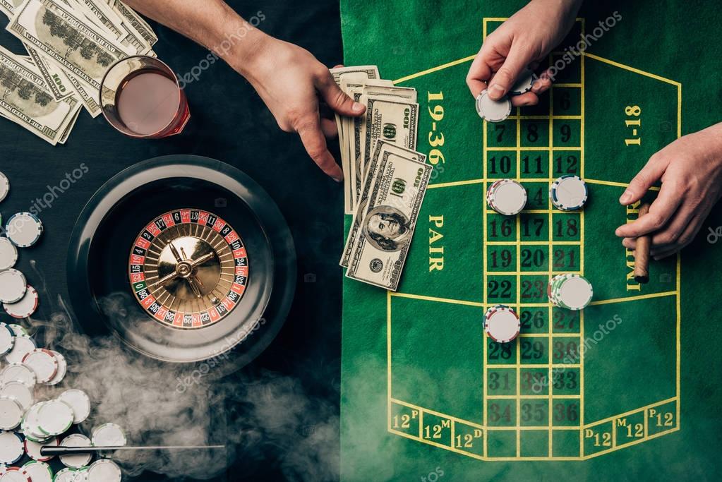Men placing a bet on casino table with roulette