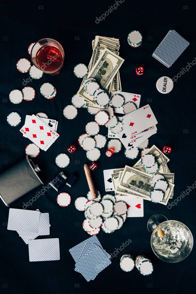 Gambling concept with alcohol on casino table with cards and dice