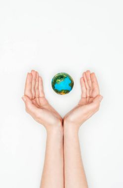 cropped image of woman holding hands around earth model isolated on white, earth day concept clipart