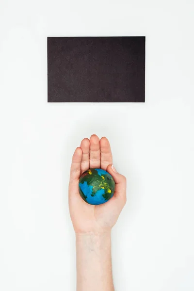 cropped image of woman holding earth model under blackboard isolated on white, earth day concept