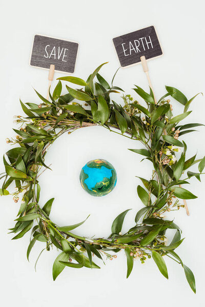 top view of earth model inside wreath with signs save earth isolated on white, earth day concept