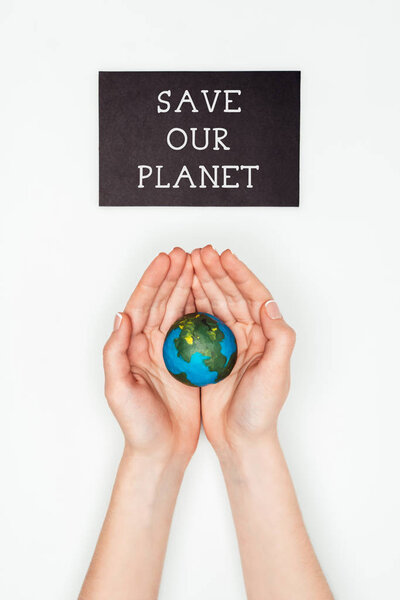 cropped image of woman holding earth model in hands under sign save our planet isolated on white, earth day concept