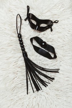 Black leather whip and ball gag with mask clipart