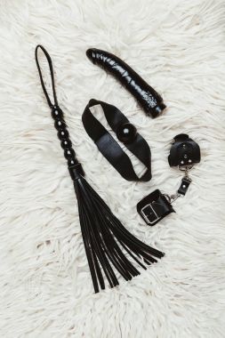Siyah bdsm gag ve vibratör ile beyaz halı üzerinde kırbaç