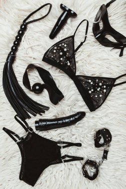 Siyah yetişkin oyuncakları ve bdsm ekipman ile halı üzerinde iç çamaşırı 